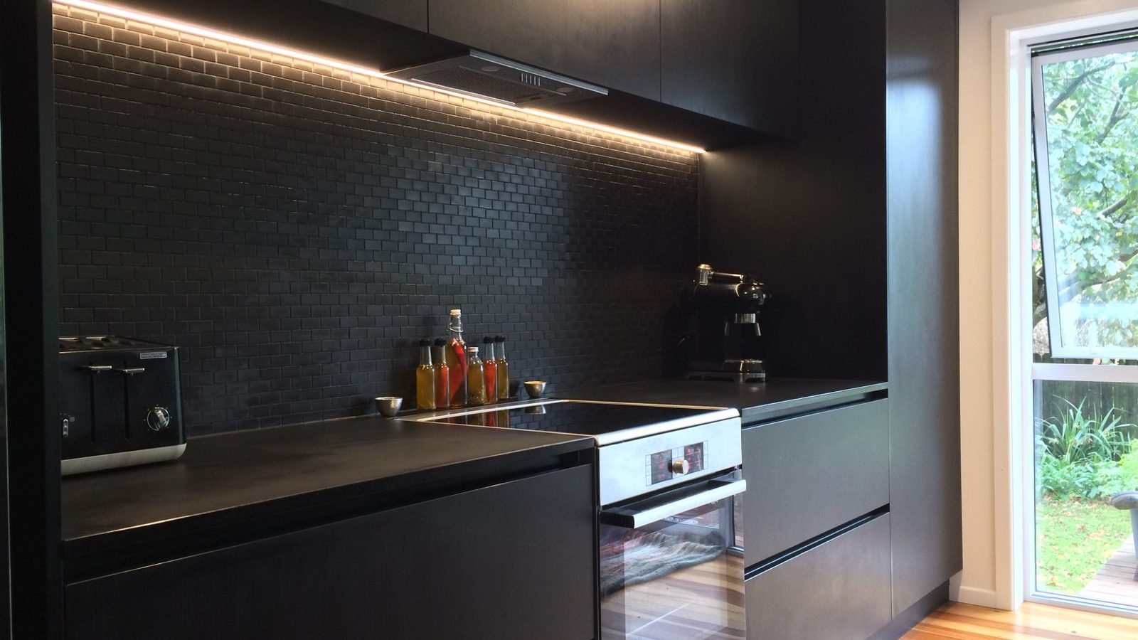 black kitchen with wooden floors